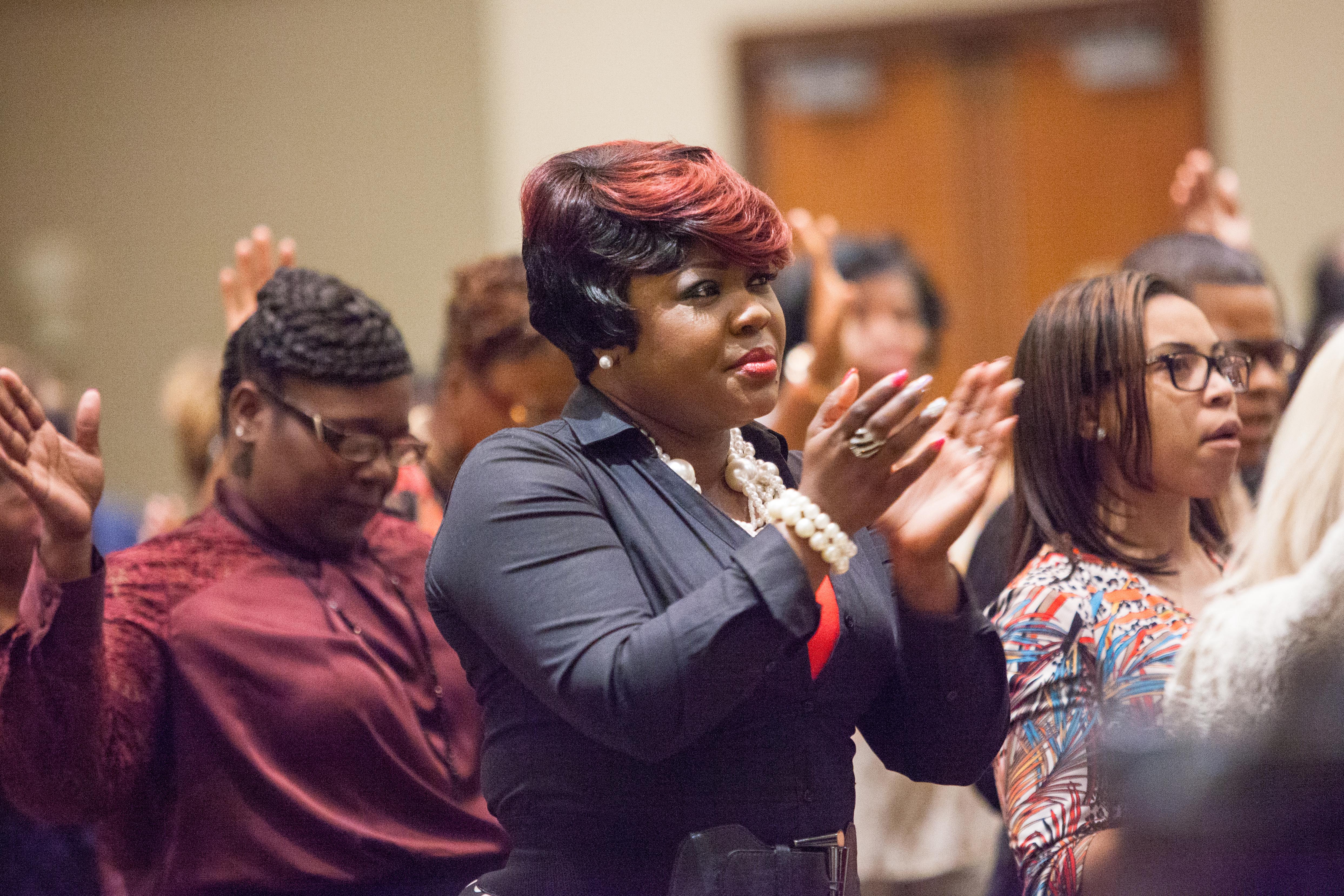 A woman claps and looks on attentively