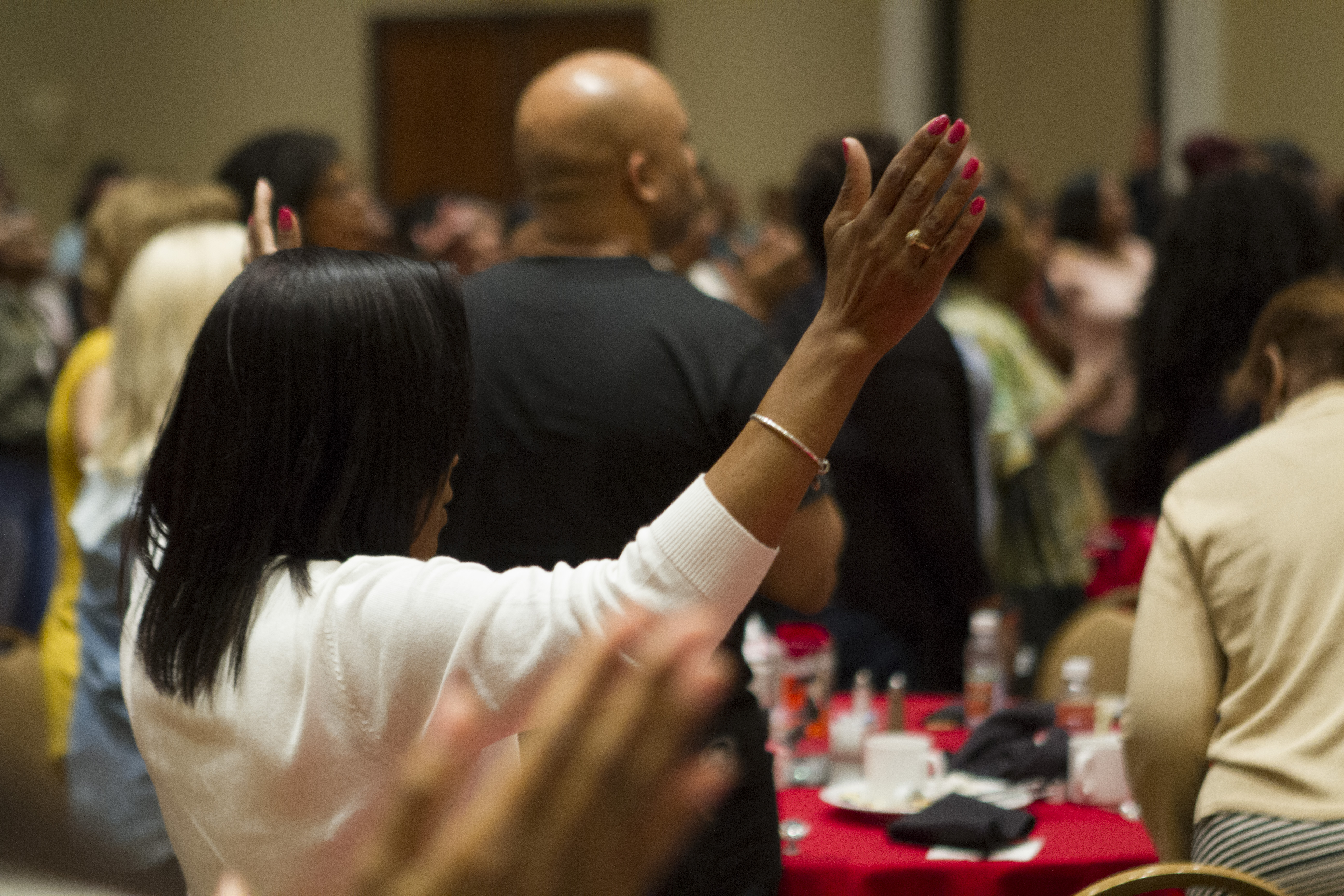 A woman lifts her hands in praise