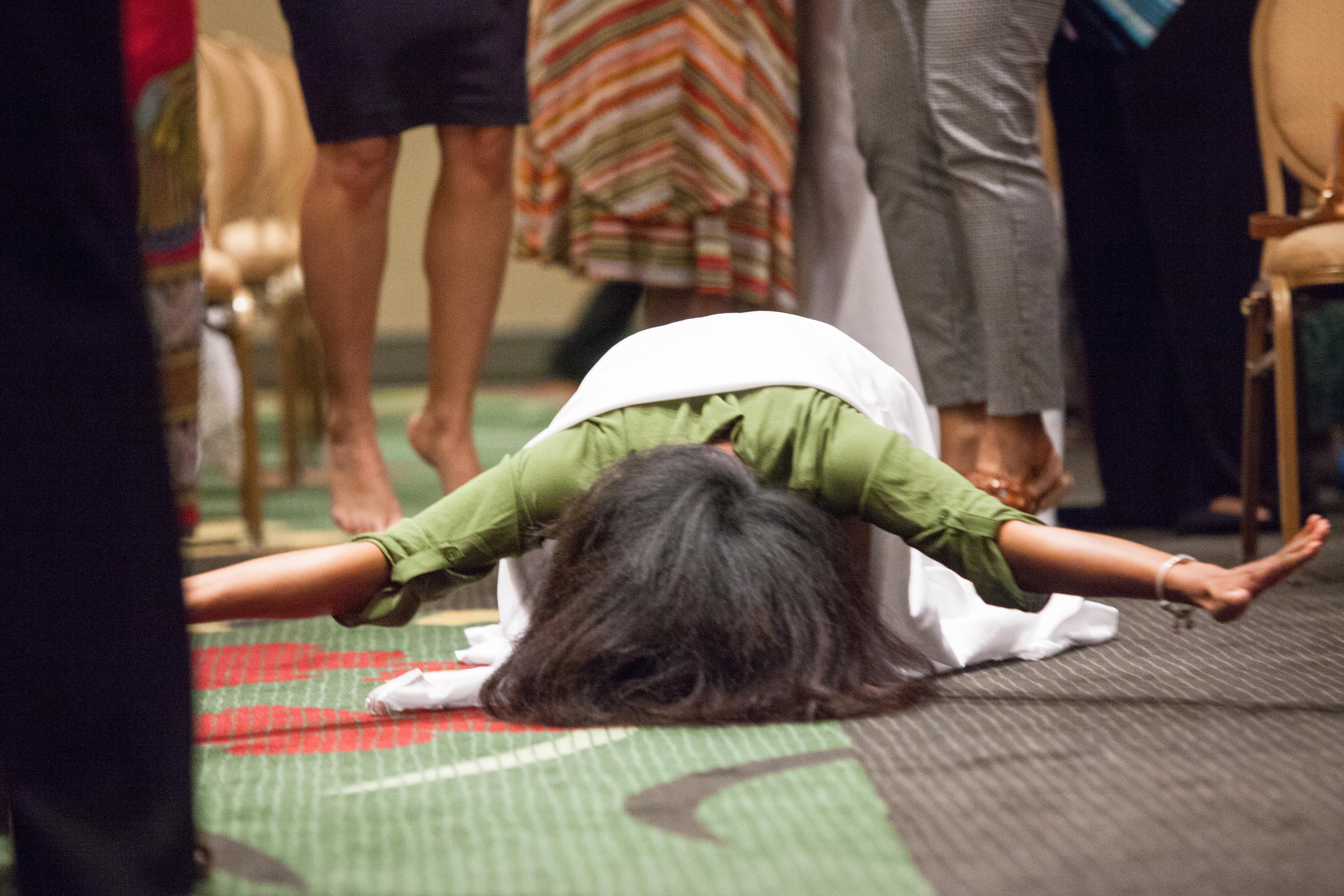 A woman lays prostrate on the floor in prayer